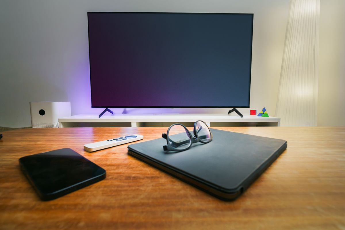 A modern living room with connected screens and a laptop