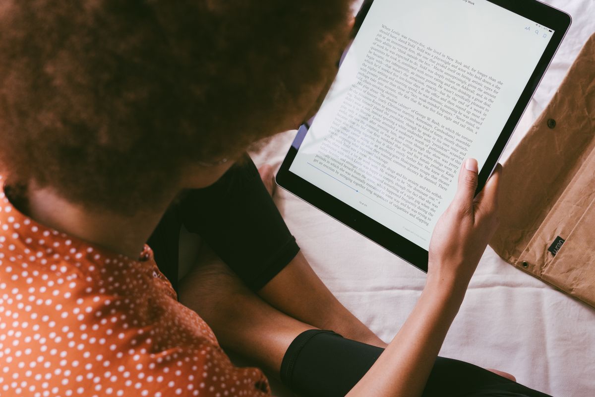 A person reading an ebook on a tablet indoors