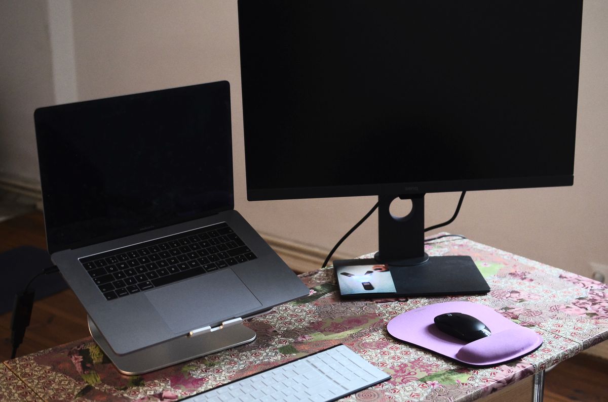 An overhead view of a laptop and monitor sharing a work desk