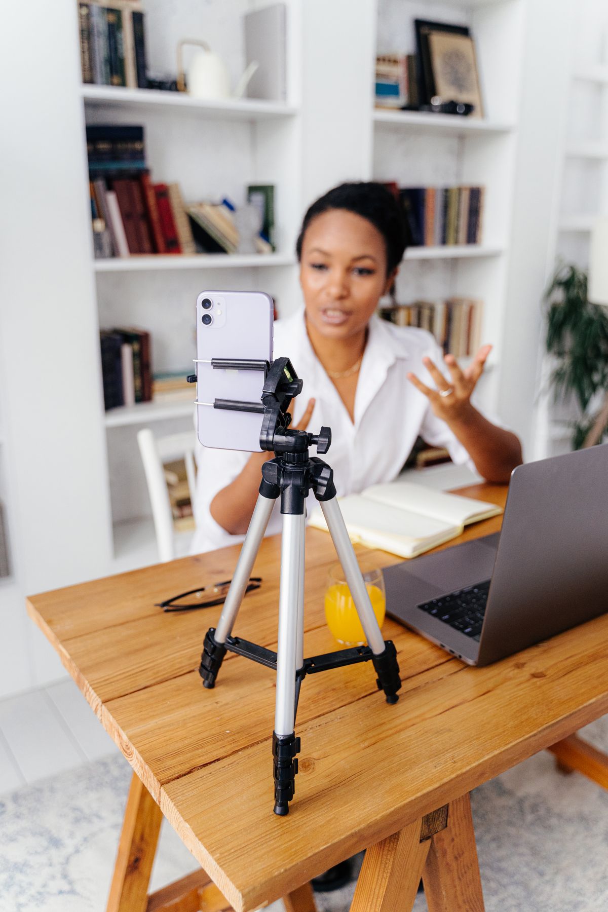 A person using a smartphone on a tripod for a home office video call